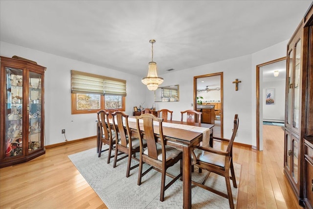 dining room featuring a baseboard heating unit and light hardwood / wood-style floors