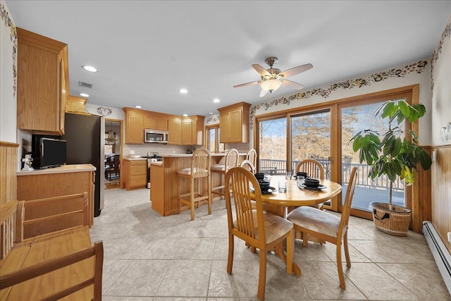 tiled dining space featuring ceiling fan and a baseboard radiator