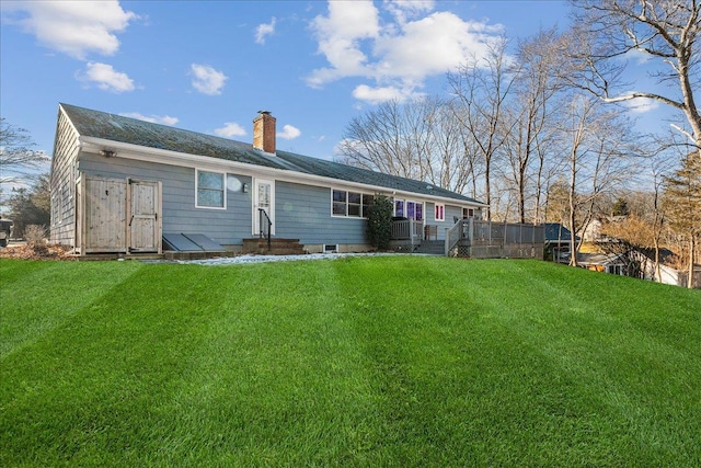 rear view of property with a deck and a lawn