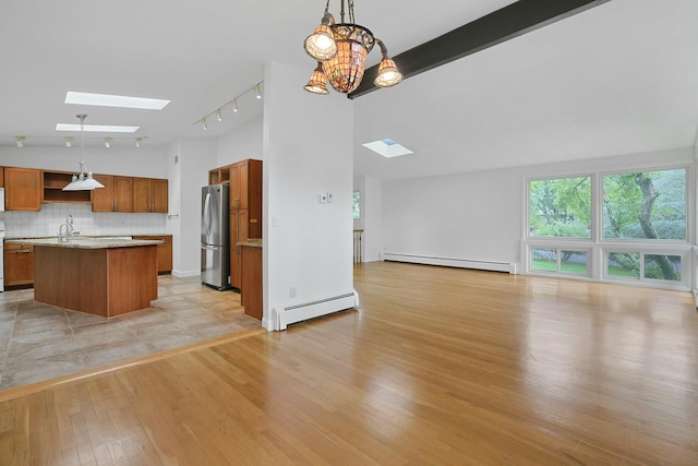 3 Dore Ct, New City, NY 10956 - kitchen with a baseboard heating unit, a skylight, baseboard heating, freestanding refrigerator, and lofted ceiling