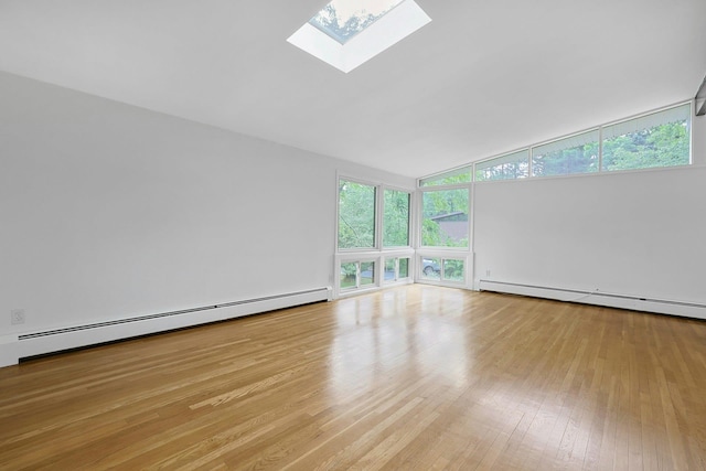 3 Dore Ct, New City, NY 10956 - spare room featuring a baseboard heating unit, a skylight, vaulted ceiling, and wood finished floors
