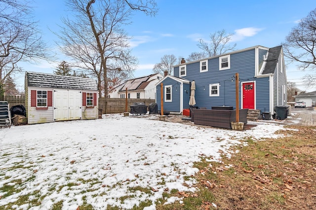 snow covered property featuring a storage unit