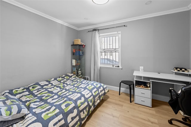 bedroom with crown molding and light hardwood / wood-style floors