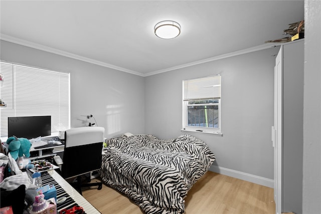 bedroom featuring ornamental molding and light hardwood / wood-style flooring