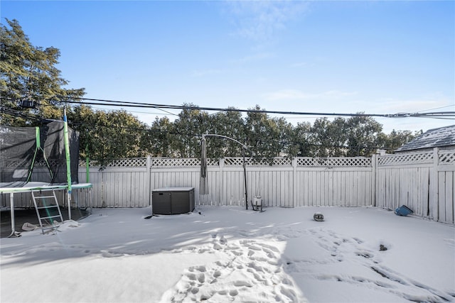 snowy yard featuring a trampoline