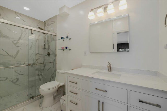 bathroom with vanity, toilet, and a shower with shower door