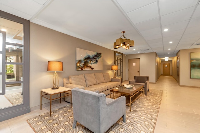 living room with a drop ceiling and a chandelier