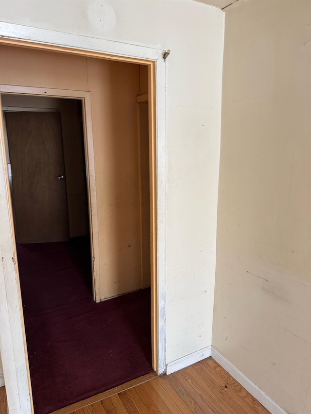 corridor with hardwood / wood-style flooring