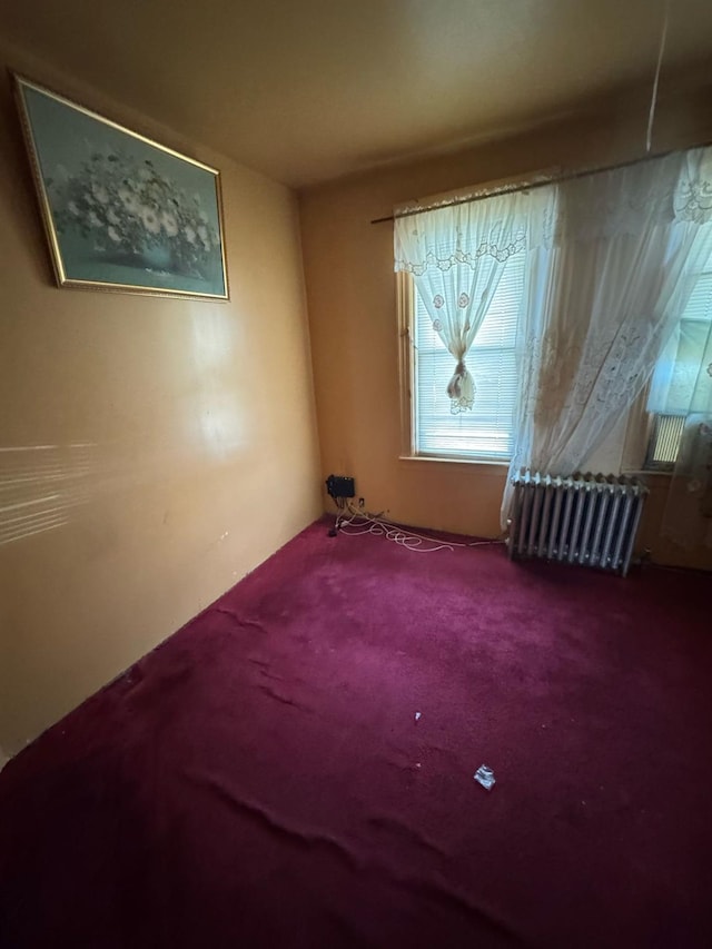 carpeted empty room with radiator heating unit