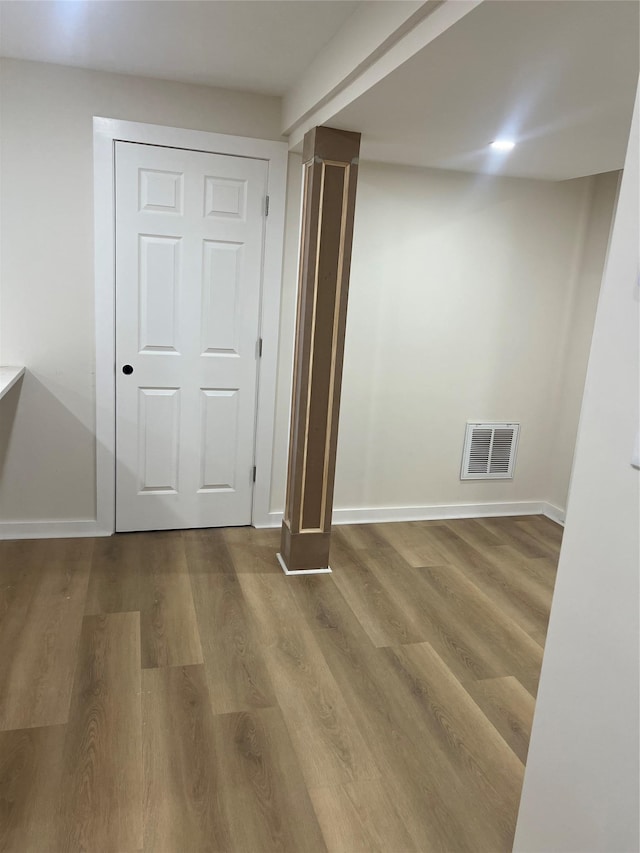 interior space featuring hardwood / wood-style flooring and ornate columns