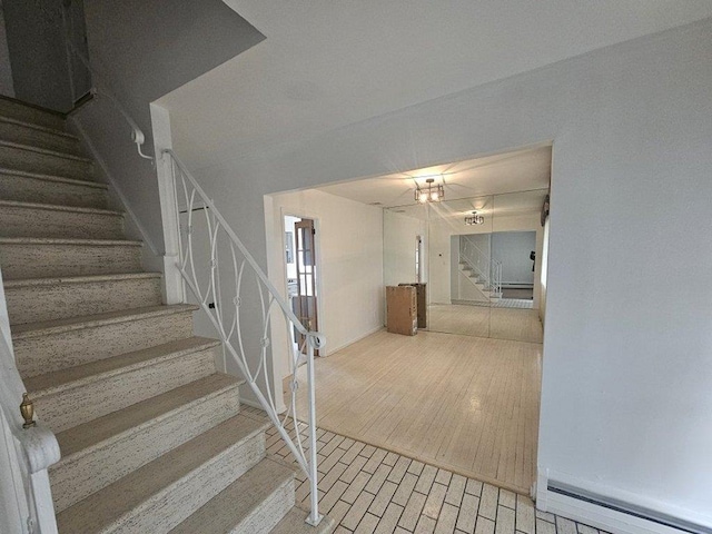 stairs featuring hardwood / wood-style flooring and a baseboard radiator