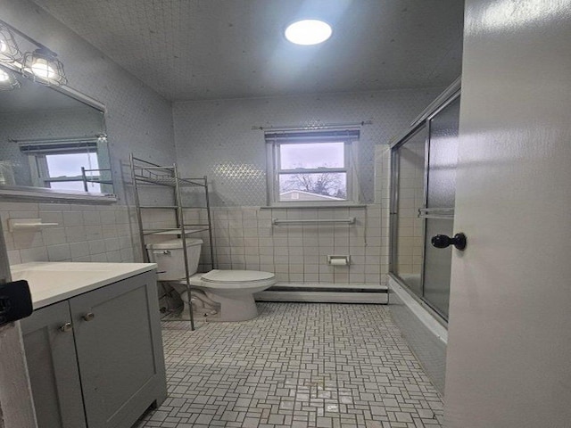 full bathroom featuring plenty of natural light, vanity, tile walls, and a baseboard heating unit