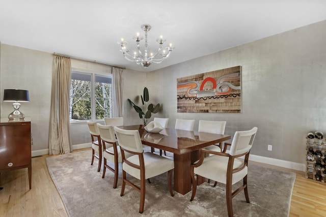 dining room featuring a notable chandelier, baseboards, and wood finished floors