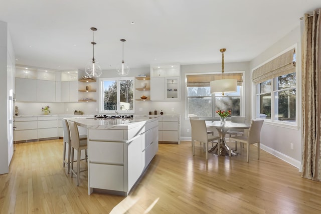 kitchen with modern cabinets, a center island, white cabinetry, and open shelves