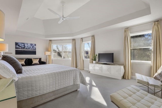 bedroom with ceiling fan, a tray ceiling, vaulted ceiling, and carpet flooring