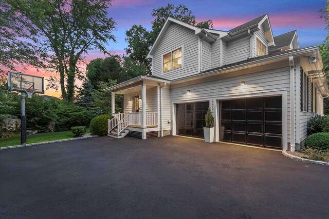 property exterior at dusk featuring driveway and an attached garage