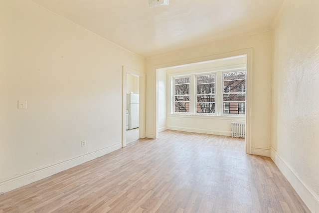 empty room with radiator and light wood-type flooring