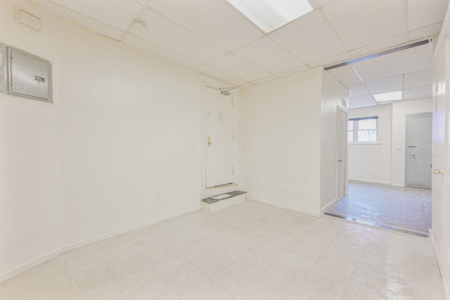 empty room with a paneled ceiling and electric panel