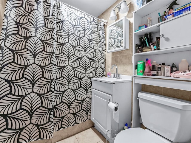 bathroom featuring vanity, toilet, tile patterned flooring, and tile walls