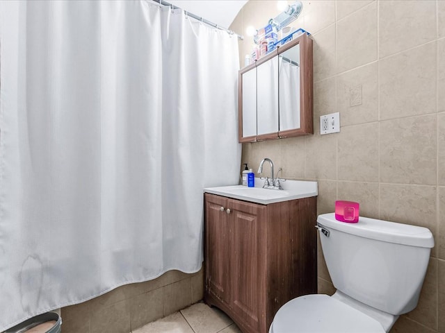 bathroom featuring tile walls, tile patterned flooring, vanity, walk in shower, and toilet