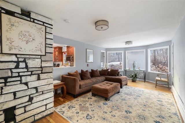 living room with a baseboard radiator and light wood-type flooring