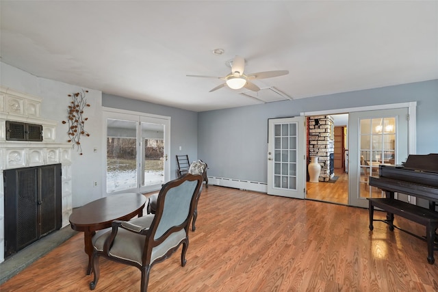 dining room featuring a baseboard radiator, ceiling fan, light wood-type flooring, and french doors