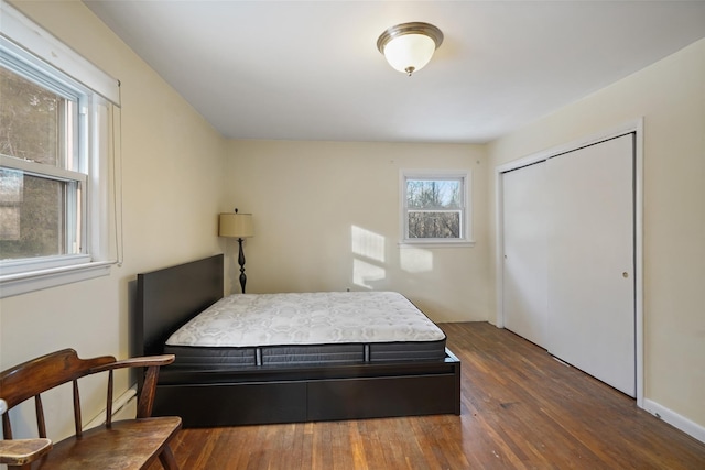 bedroom with dark hardwood / wood-style flooring and a closet