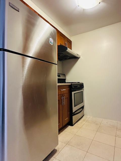 kitchen with light tile patterned flooring and appliances with stainless steel finishes