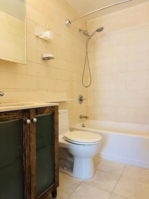 full bathroom with tile patterned flooring, vanity, tiled shower / bath, and toilet