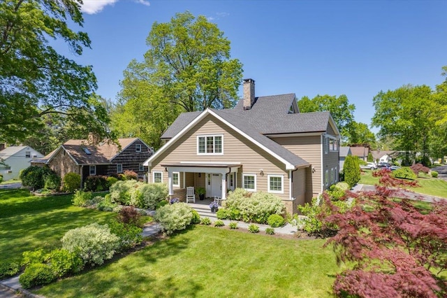 4 Clover Pl, New Rochelle, NY 10805 - back of house with a porch, a chimney, and a lawn