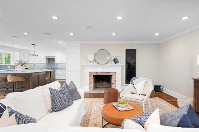 4 Clover Pl, New Rochelle, NY 10805 - living room with wood finished floors, a stone fireplace, recessed lighting, crown molding, and baseboards