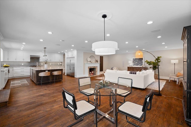 4 Clover Pl, New Rochelle, NY 10805 - dining area with recessed lighting, a lit fireplace, dark wood finished floors, crown molding, and baseboards