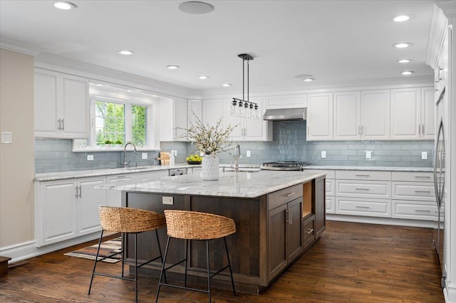 4 Clover Pl, New Rochelle, NY 10805 - kitchen with extractor fan, a sink, white cabinets, a breakfast bar, and ornamental molding