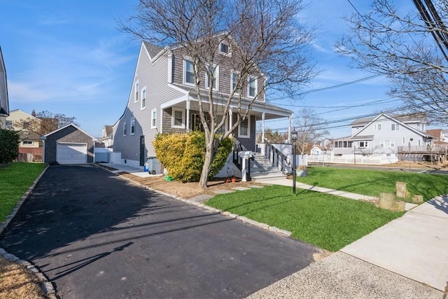 view of front of property with a garage, an outdoor structure, a front lawn, and a porch