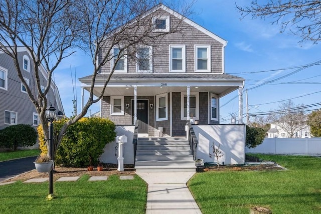 view of front of house featuring covered porch and a front lawn