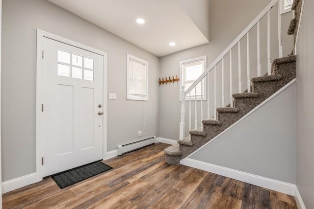 foyer entrance with a baseboard heating unit and wood-type flooring