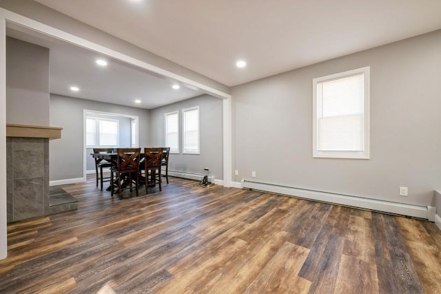 dining area with a baseboard radiator, dark wood-type flooring, and beam ceiling