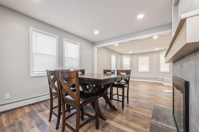 dining area with a baseboard heating unit and dark hardwood / wood-style floors