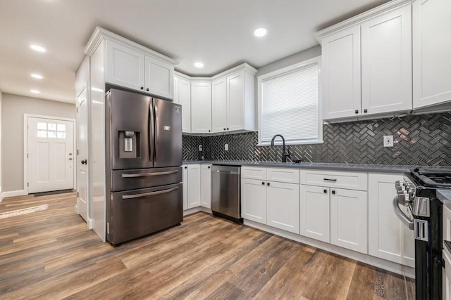 kitchen featuring white cabinetry, sink, hardwood / wood-style floors, and appliances with stainless steel finishes