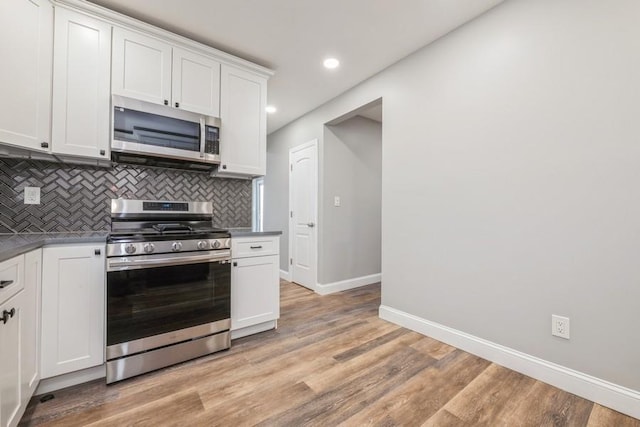 kitchen featuring white cabinetry, stainless steel appliances, decorative backsplash, and light hardwood / wood-style flooring