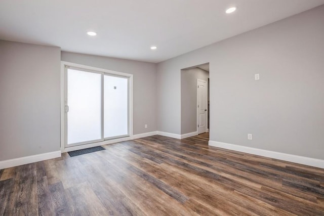 unfurnished room with dark hardwood / wood-style flooring