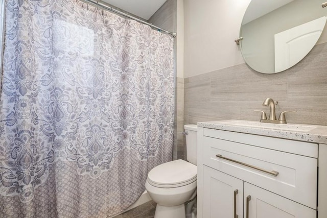 bathroom featuring a shower with curtain, vanity, toilet, and tile walls