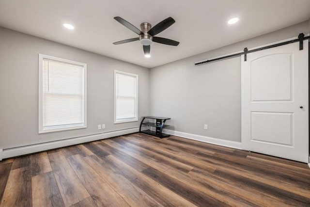 interior space with ceiling fan, a barn door, dark wood-type flooring, and baseboard heating