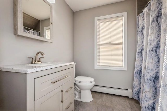 bathroom featuring a baseboard radiator, vanity, toilet, and plenty of natural light