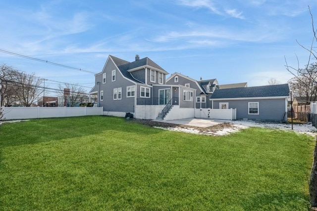 rear view of house with a yard and a patio area