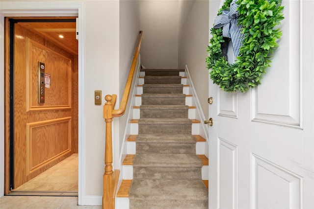 stairs featuring tile patterned flooring and elevator