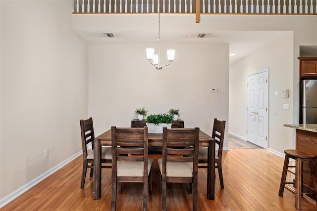 dining space with an inviting chandelier and light wood-type flooring