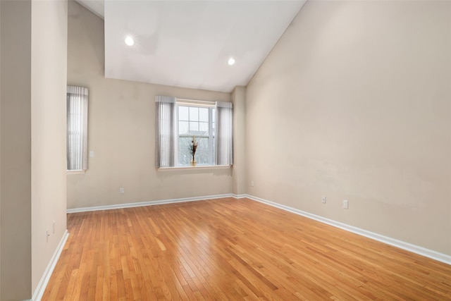 spare room featuring light hardwood / wood-style flooring and high vaulted ceiling