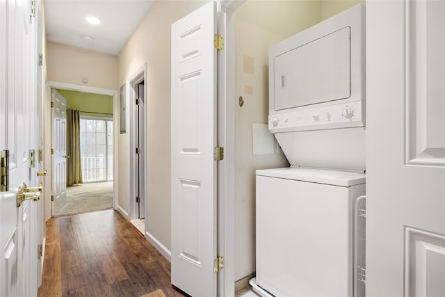 washroom with stacked washer / drying machine and dark hardwood / wood-style floors