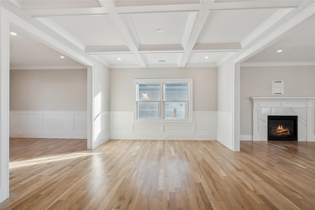 unfurnished living room featuring a premium fireplace, beam ceiling, coffered ceiling, light hardwood / wood-style floors, and ornamental molding